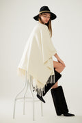 Soft knitted poncho in beige with fringes
