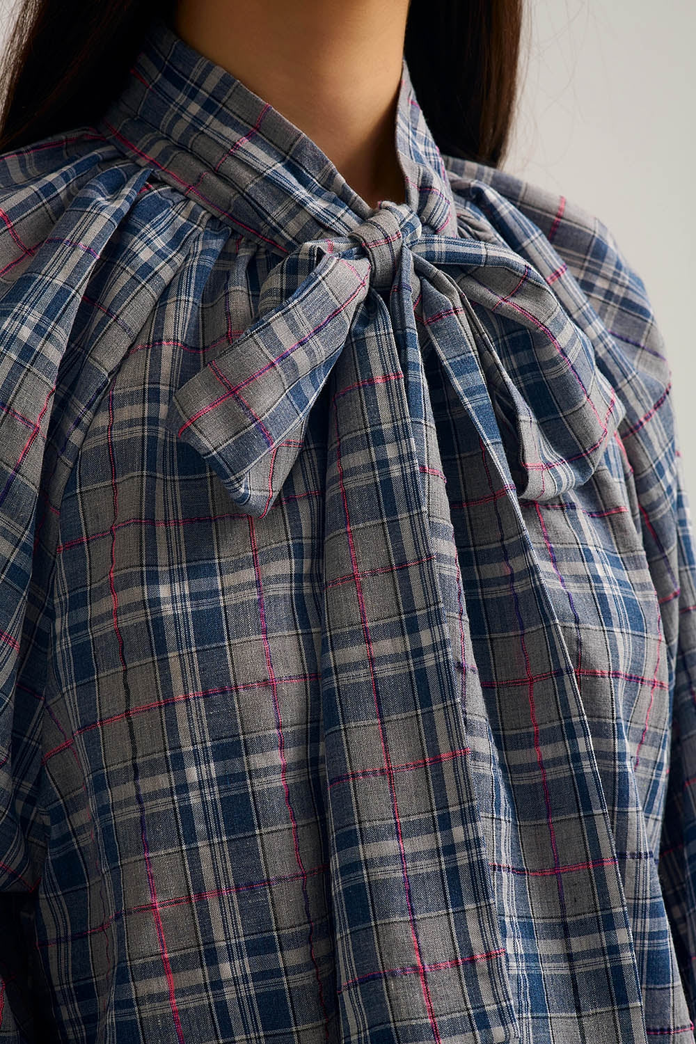 Blue blouse with check print and bow detail at the neck