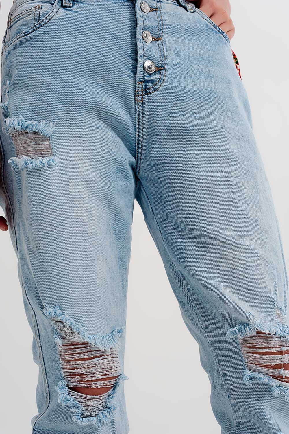 Straight leg distressed jeans with button detail in light blue