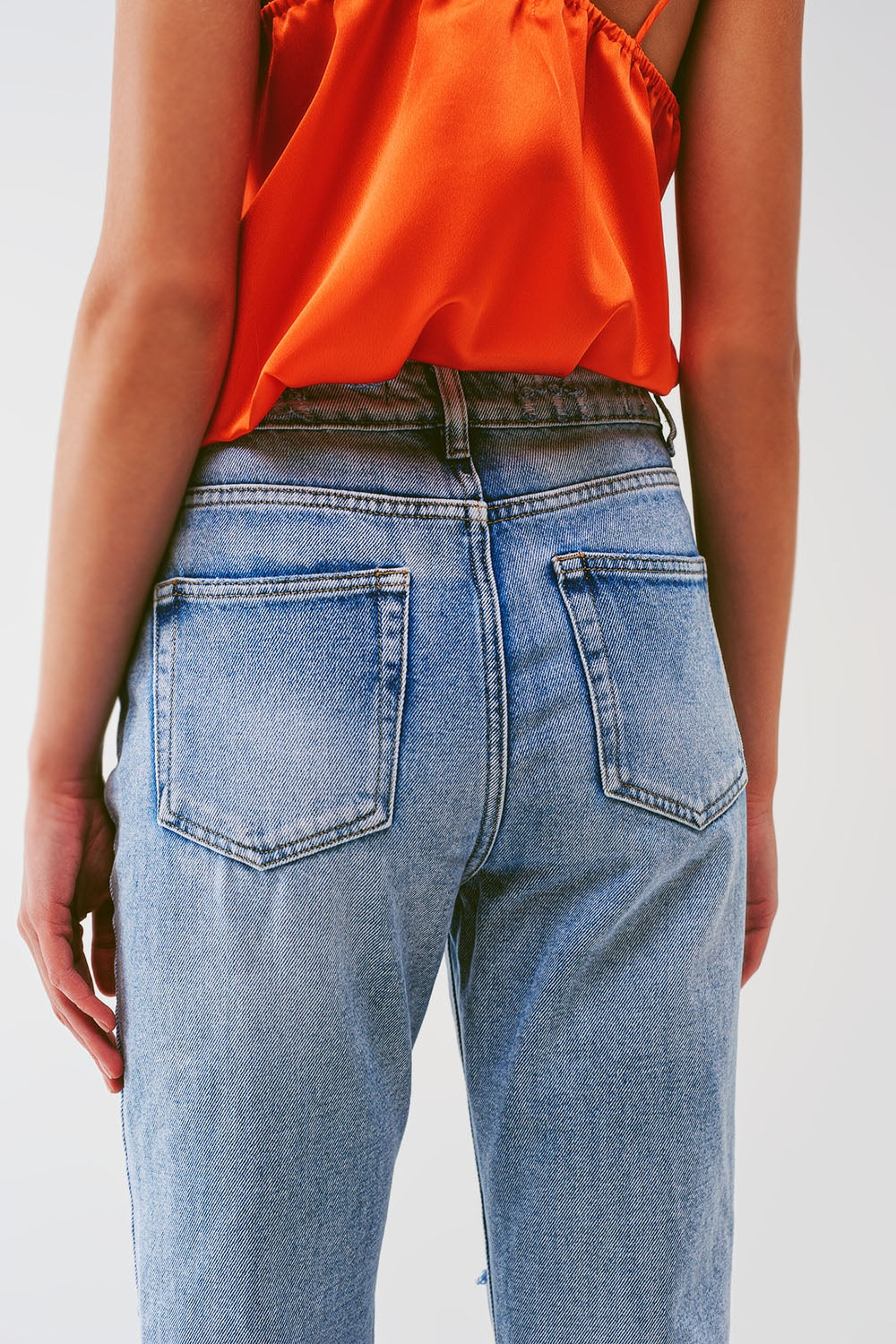 Sraight-leg jeans with exposed buttons and ripped knees in light wash