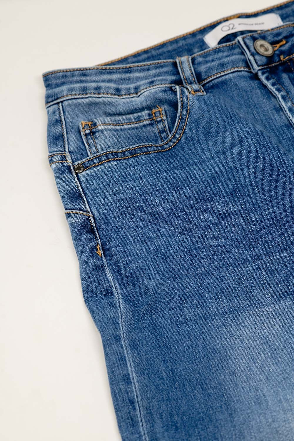 Basic straight jeans with five pockets and frontal metalic button closure