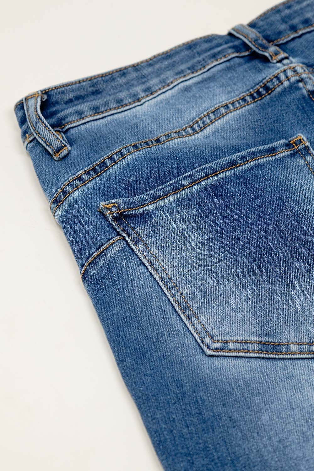 Basic straight jeans with five pockets and frontal metalic button closure