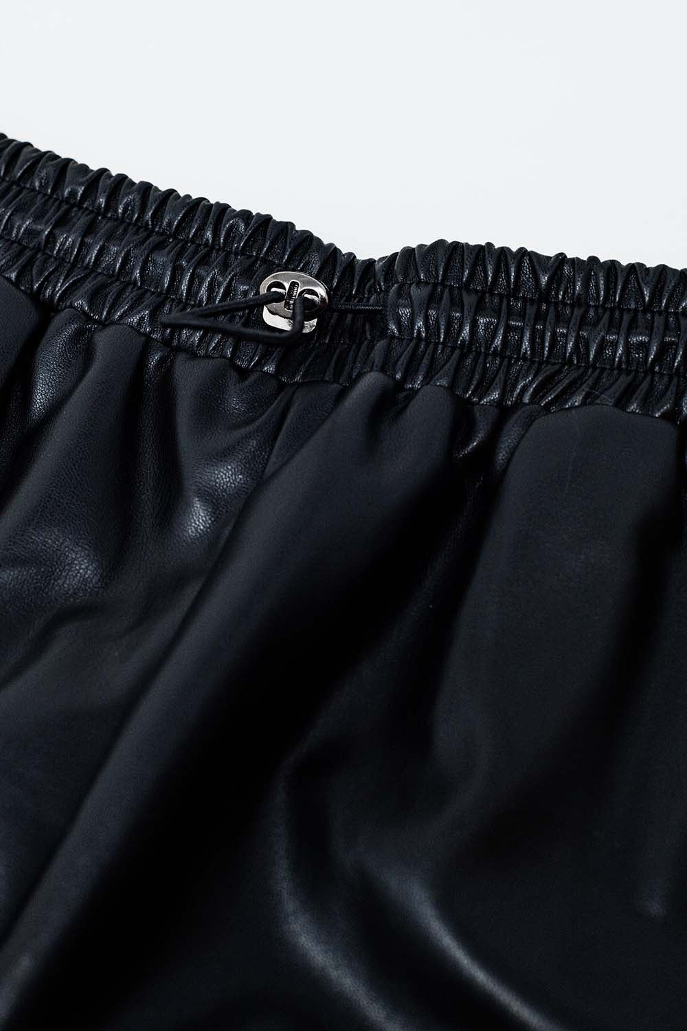 Black faux leather shorts with gathering at the waist with drawstring