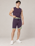 AI-generated styling illustration: adult male wearing UNIKCOSA Aubergine Sage Arc shorts with a coordinated fitted sleeveless top, gently lifting its hem to show the waistband.