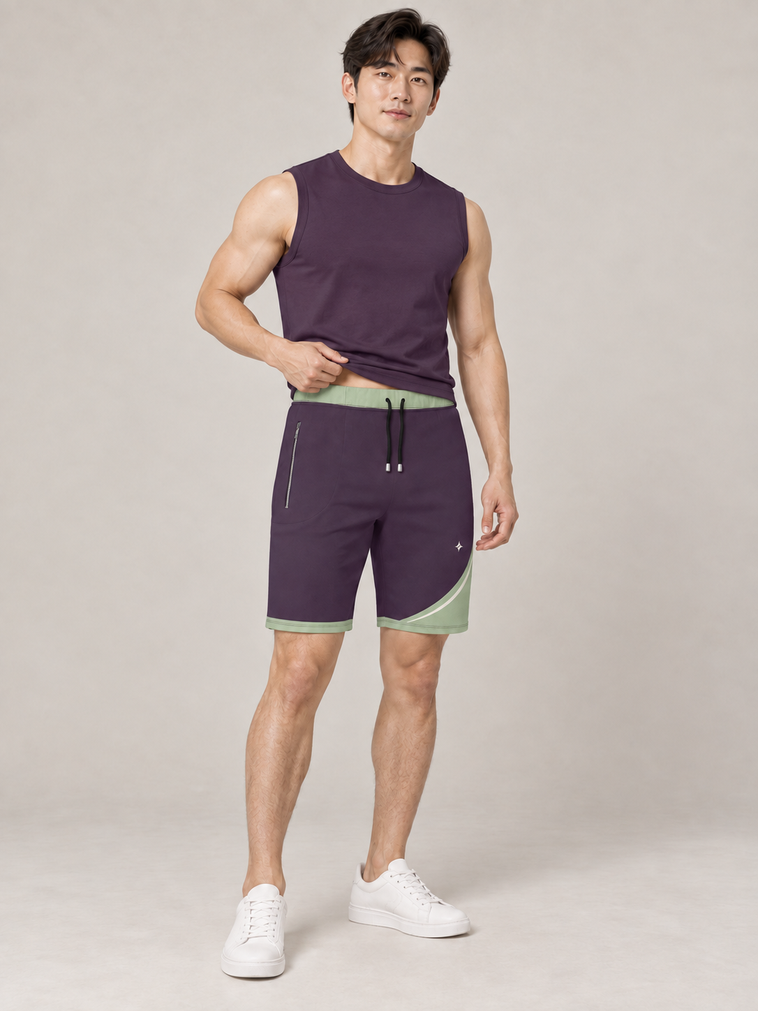 AI-generated styling illustration: adult male wearing UNIKCOSA Aubergine Sage Arc shorts with a coordinated fitted sleeveless top, gently lifting its hem to show the waistband.