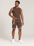 AI-generated styling illustration: adult male wearing UNIKCOSA Cocoa Apricot Frame shorts with a coordinated fitted sleeveless top, gently lifting its hem to show the waistband.
