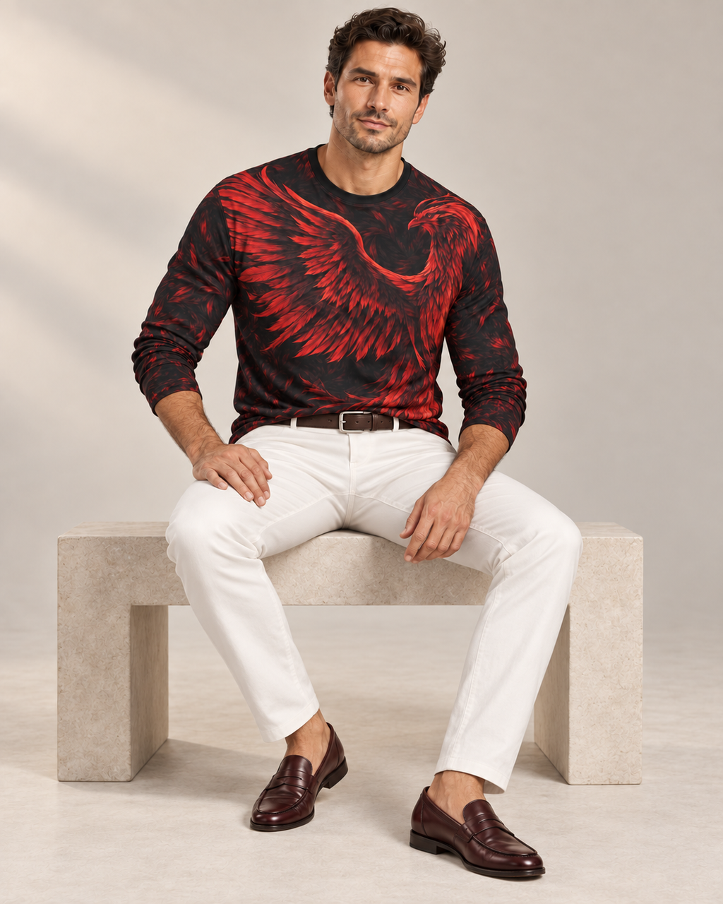 Fire Phoenix Luxury Long Sleeve T-Shirt by UNIKCOSA, seated view with white tailored trousers and cherry-brown loafers — AI-generated model illustration