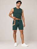 AI-generated styling illustration: adult male wearing UNIKCOSA Forest Clay Frame shorts with a coordinated fitted sleeveless top, gently lifting its hem to show the waistband.