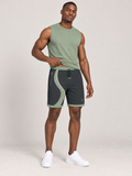 AI-generated styling illustration: adult male wearing UNIKCOSA Graphite Sage Stream shorts with a coordinated fitted sleeveless top, gently lifting its hem to show the waistband.