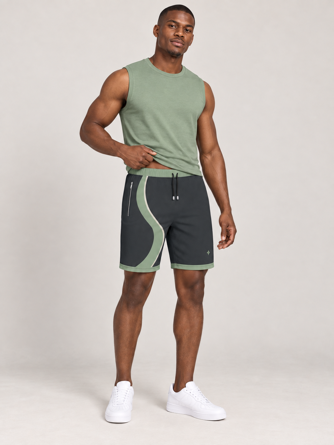 AI-generated styling illustration: adult male wearing UNIKCOSA Graphite Sage Stream shorts with a coordinated fitted sleeveless top, gently lifting its hem to show the waistband.