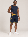 AI-generated styling illustration: adult male wearing UNIKCOSA Midnight Saffron Frame shorts with a coordinated fitted sleeveless top, gently lifting its hem to show the waistband.
