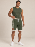 AI-generated styling illustration: adult male wearing UNIKCOSA Olive Trail Chevron shorts with a coordinated fitted sleeveless top, gently lifting its hem to show the waistband.
